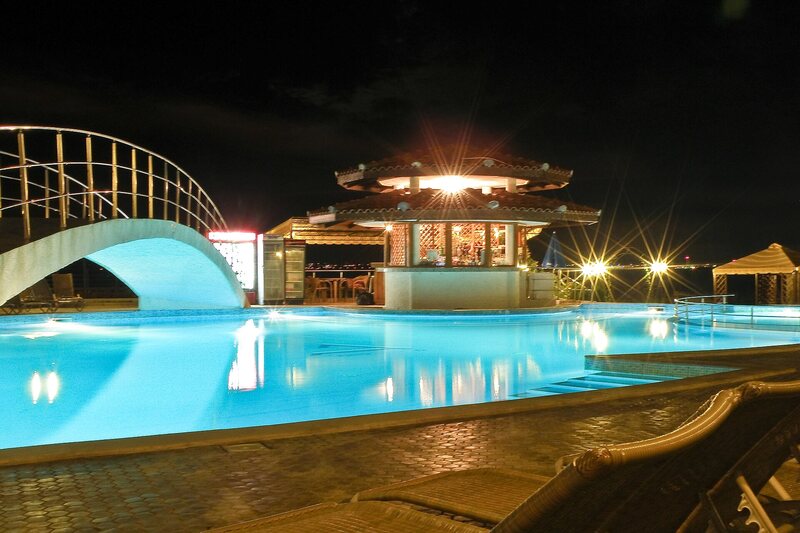 Pool at night with bridge and rooftop bar